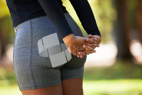 Image of Stretching, hands and butt of woman at park for health, wellness and flexibility. Sports, training and female athlete outdoors in nature preparing, warm up and getting ready for workout or exercise.