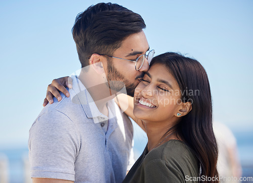 Image of Love, blue sky and couple hug, kiss and enjoy outdoor quality time together on romantic summer vacation date. Ocean beach, freedom peace and man and woman bond on travel holiday in Miami Florida USA