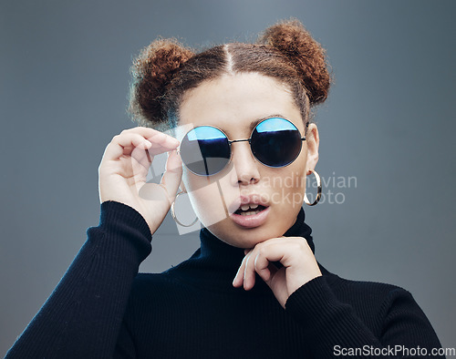Image of Face, sunglasses and fashion with young woman, style and designer with trendy brand and gen z against studio background. Style, edgy and young girl, marketing with fashion model and stylish beauty
