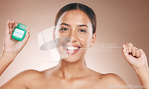 Image of Woman cleaning teeth with dental floss, portrait of girl with happy smile and studio with brown background. Oral hygiene with healthcare product, cosmetic maintenance for healthy mouth and flossing