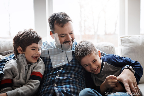 Image of Bonding, hug and father with children on the sofa for love, care and relax in their family home. Happy, funny and dad with boy kids for quality time, affection and comedy on the couch of a house