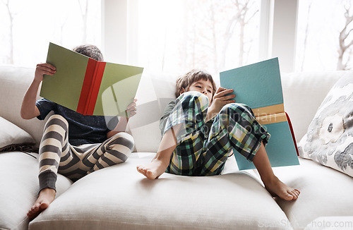 Image of Kids, boys or reading books for education, learning or relax studying on house living room or home sofa. Children, storytelling and fantasy fairytale novel in hobby activity or creative inspiration