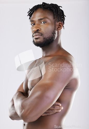 Image of Confident, muscular and portrait of a black man with arms crossed isolated on a grey studio background. Fitness, health and African athlete with muscle, power and bodybuilding body on a backdrop