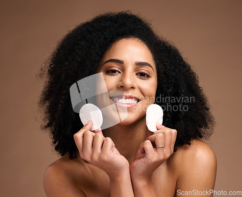 Image of Skincare, face portrait and black woman with cotton in studio isolated on a brown background. Cosmetics, wellness and happy female model holding facial pad or product for cleaning makeup for hygiene.