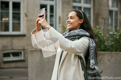 Image of Travel, tourism and phone with a woman in the city taking a photograph while traveling on holiday or vacation. Tourist, traveler and mobile with a female photographing while sightseeing abroad