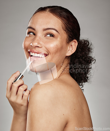 Image of Woman, lipstick and beauty makeup cosmetics for skincare or glow against a grey studio background. Happy female smiling with teeth in satisfaction for lip, mouth and applying cosmetic treatment