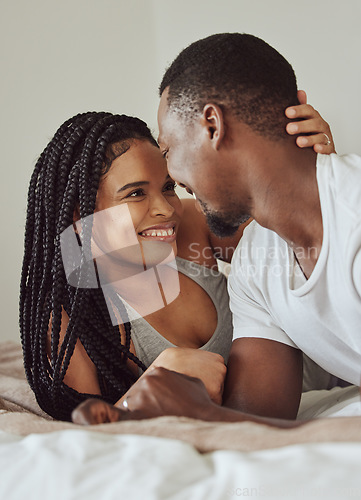 Image of Black couple, love and home bedroom bonding while happy together on a bed in a house, apartment or hotel. Young man and woman intimate in a healthy marriage with commitment, happiness and care