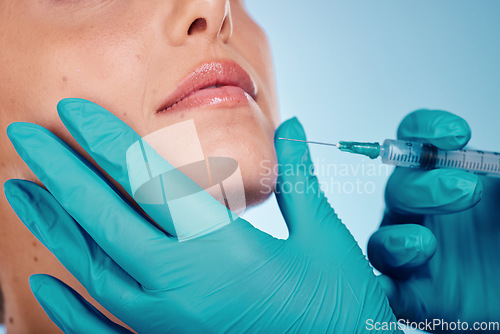 Image of Botox, hands and cosmetic surgery with a woman and doctor in studio on a blue background for face change. Beauty, skin and injection with a surgeon holding a syringe for female client facial filler