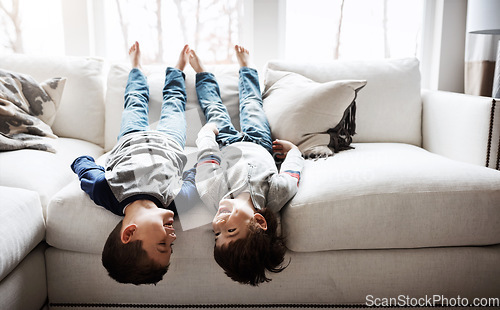 Image of Children upside down, playful and happy at family home for fun with sibling, brothers on sofa and relax in living room. Happy people, love and quality time together, kid boys play with laughing