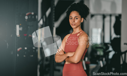 Image of Black woman, fitness and coach with arms crossed for workout, training or exercise standing in the gym. Portrait of a confident African American female sports instructor with vision for healthy body