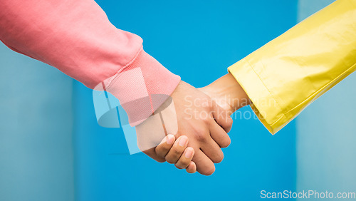 Image of Couple, love and holding hands together for support care, relationship and bonding in blue background studio. Man, woman and hand for partnership, romance trust and solidarity or compassion lifestyle