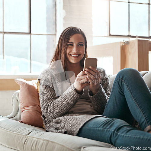 Image of Thinking, phone and woman relax on a sofa, happy and smile while chatting online in her home. Idea, girl and smartphone app for online dating, social media and streaming while resting in living room