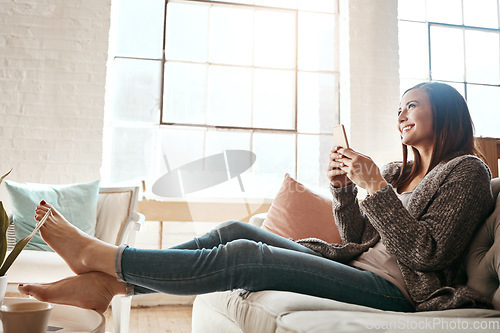 Image of Internet, phone and woman relax on a sofa with social media, texting and browsing in her home. Girl, smartphone and online chatting, app and online dating while streaming and resting in a living room