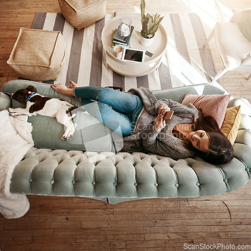 Image of Woman relax on couch with phone, social media scroll and communication at home, contact and technology. Happy woman, smile for meme and web search with streaming, smartphone and rest on sofa top view