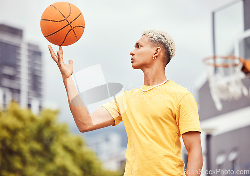 Image of Sports, fitness and man spinning basketball on court outdoors before workout, exercise or practice. Basketball court, balance and young male player with ball on finger getting ready for training.