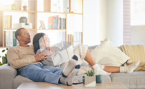 Image of Senior couple, relax and sofa for hug, thinking or memory of life, love memory or bonding in home living room. Mature man, old woman and embrace on lounge couch for vision, care or support in Florida