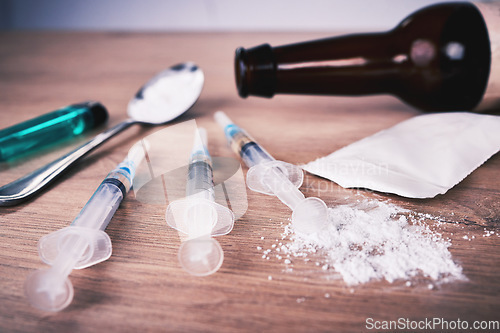 Image of Powder, syringe and drugs with spoon on table for alcohol addiction, drug rehabilitation and narcotics abuse. Medicine, illegal products and drug problem for meth, cocaine and heroin solution