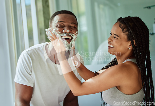 Image of Shaving, playful and fun with a black couple laughing or joking together in the bathroom of their home. Love, shave and laughter with a man and woman being funny while bonding in the morning