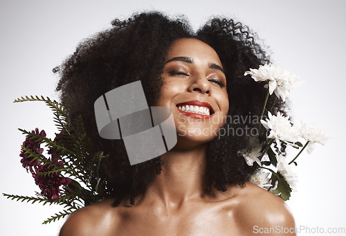 Image of Black woman, beauty and flowers on studio background for healthy skincare. Happy face, floral plants and model with spring perfume, natural makeup and eco wellness for cosmetics, aesthetics and smile