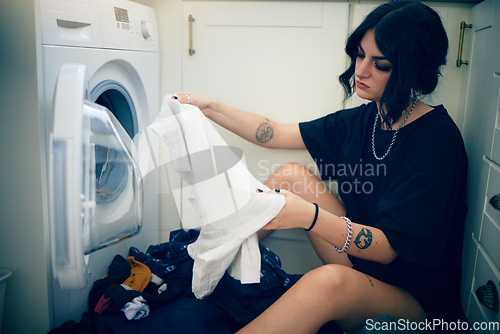 Image of Laundry, cleaning and housework with a woman using the washing machine in her home for domestic responsbility. Appliance, fabric and clothes with a female cleaner on her apartment floor to wash