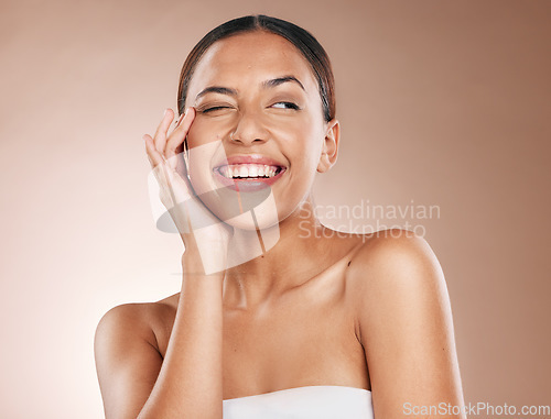 Image of Skincare, beauty and happiness, portrait of woman with smile laughing on studio background. Makeup, glamour and wink, luxury skin care with hands on face, natural detox facial massage on happy woman