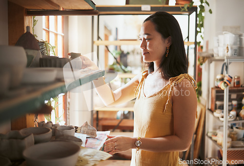 Image of Pottery, startup and display with a woman entrepreneur working in a studio, selling products for retail. Small business, manager or sale with a female owner at work in a workshop for artistic design