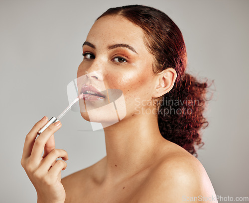 Image of Woman, makeup portrait and lip gloss application for beauty, cosmetics dermatology and skincare wellness in grey background. Female model, face and lipstick brush or lip balm product for self care