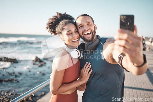 Image of Fitness, couple and phone in beach selfie with smile for running, exercise or workout in the outdoors. Happy man and woman smiling in happiness looking at smartphone for photo after run by the ocean