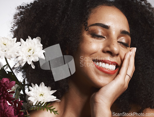 Image of Makeup, flowers and happy black woman with skincare satisfaction and glowing texture routine. Aesthetic, health and wellness of confident cosmetics model with beautiful smile in white studio.