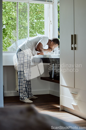 Image of Black man brushing his teeth for dental health, hygiene or wellness in the bathroom of his home. Grooming, healthcare and young African guy cleaning his mouth for an oral care morning routine.