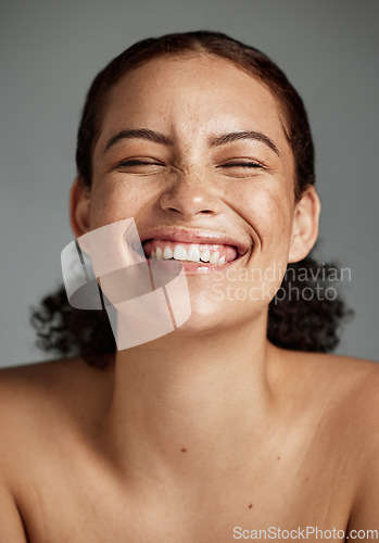 Image of Face, beauty and funny with a model black woman in studio on a gray background laughing for skincare. Facial, wellness and makeup with an attractive young female happy with her skin product