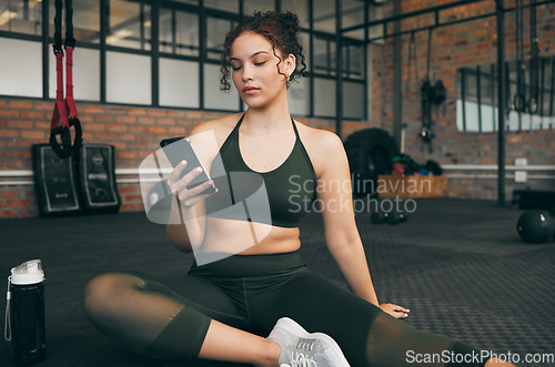 Image of Woman, fitness and phone at gym for a workout, training and body wellness with a mobile app. Young sports female with smartphone for progress, performance and communication for a healthy lifestyle