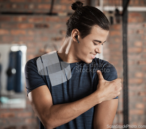 Image of Arm, shoulder muscle hold and man in a exercise, fitness and wellness gym happy about target goal. Sports, athlete and healthy young person with a smile after training and workout in a health club