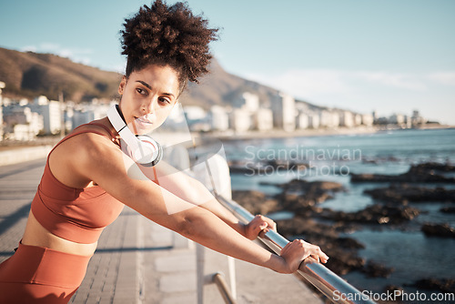 Image of Black woman, fitness rest and music on beach for exercise training, cardio wellness and workout outdoor. African girl, thinking and relax mindset or runner break with radio for health by ocean sea