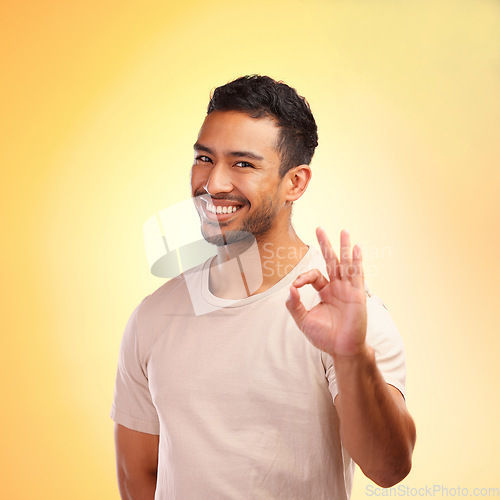 Image of Portrait, hands and man with ok sign in studio isolated on yellow background. Hand gesture, okay emoji and happy young male model with symbol for approval, success or motivation, support or thank you