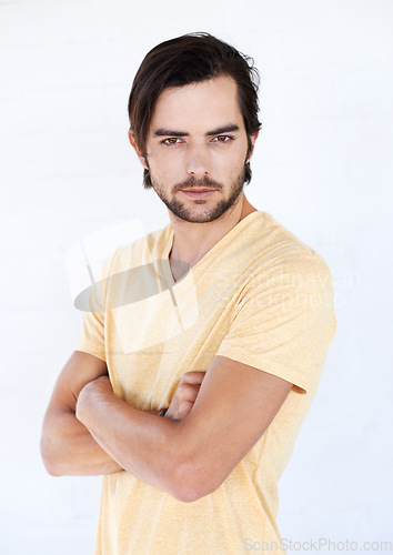 Image of Man, studio portrait and arms folded for confidence, focus or vision with t-shirt by white background. Isolated casual model, handsome male and motivation in trendy fashion, relax lifestyle or beauty