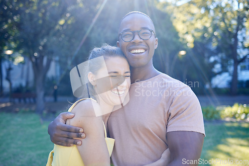 Image of Happy interracial couple, hug and laughing in joy for bonding relationship together in the park. Man hugging woman smiling in happiness for love, embrace and sharing a laugh for funny joke in nature