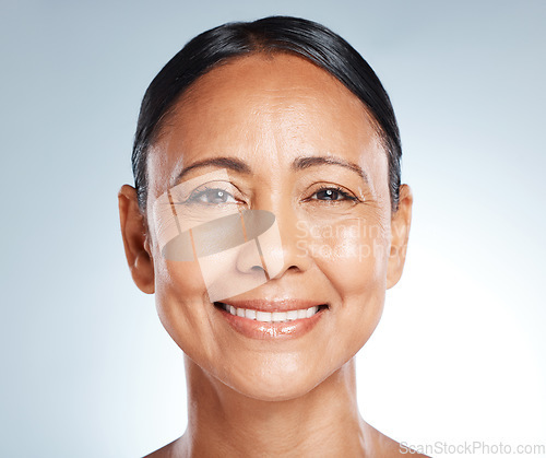 Image of Smile, skincare and portrait of a senior woman with beauty isolated on a blue background in studio. Anti aging, health and face of an elderly model happy about facial dermatology on a backdrop