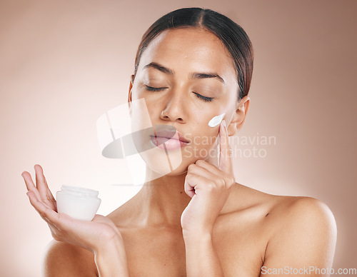 Image of Cream, skincare and woman with a dermatology product for beauty glow, advertising spa and face wellness against a studio background. Promotion, skin and model marketing sunscreen for facial care