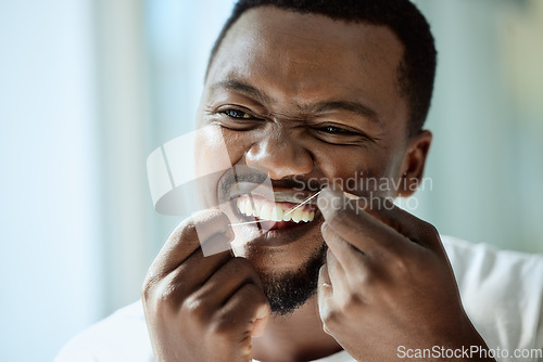 Image of Health, beauty and teeth of black man with dental floss for morning oral hygiene routine with focus. Dental care, self care and wellness of person cleaning and checking teeth in bathroom mirror.