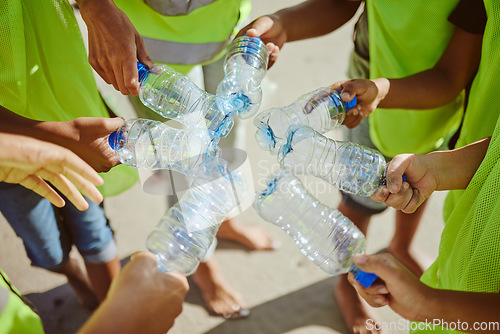 Image of Hands group, circle and plastic bottles in beach waste management, community service and climate change volunteering. Kids diversity, teamwork and trash cleaning in environment sustainability recycle