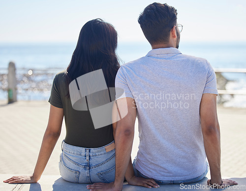 Image of Beach, view and love with a couple on the promenade together outdoor during summer by the sea or ocean. Back, date and vacation with a man and woman bonding while on holiday by the coast or water