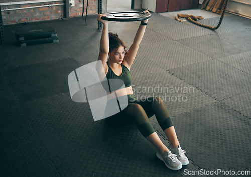 Image of Exercise, weight plate and woman at gym for workout, fitness and training for health and body wellness. Strong sports female or bodybuilder on floor doing weightlifting for power, energy and balance