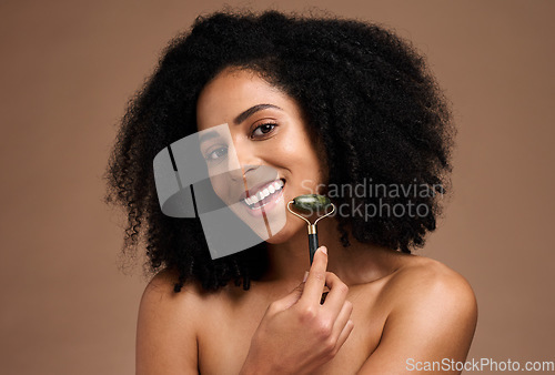 Image of Black woman, beauty and portrait with a facial roller on skin for a massage with a smile, glow and happiness. Face of aesthetic model with afro hair and dermatology cosmetic tool for spa treatment