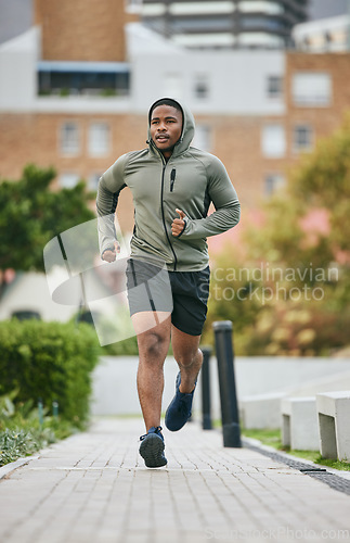 Image of Fitness, exercise and black man running in city in winter for health, wellness and strength. Sports, thinking and male runner exercising, cardio jog or training outdoors alone on street for marathon.