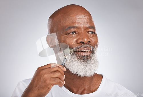 Image of Senior black man, skincare and facial roller to massage skin during self care for wellness, dermatology and cosmetics. Headshot of male with beauty tool on grey studio background for a spa treatment