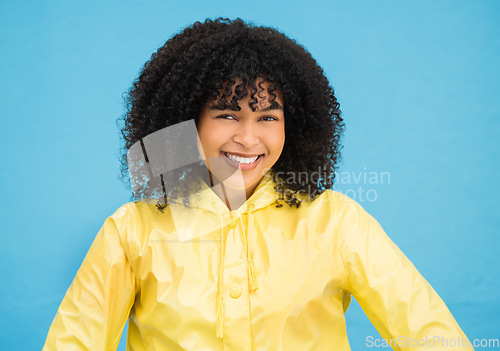 Image of Black woman, smile and happy in portrait with fashion for winter, rain coat and beauty isolated on blue background. Happiness in studio, style and success with mockup, trendy and female headshot