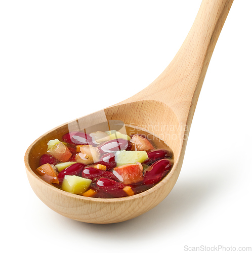 Image of vegetable soup in wooden ladle