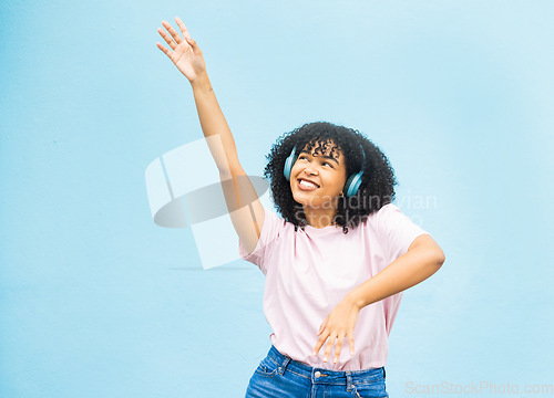Image of Wall, black woman and dance with smile, celebration and relax on blue studio background. African American female, lady and dancing with headphones, movement and excited with casual outfit on backdrop