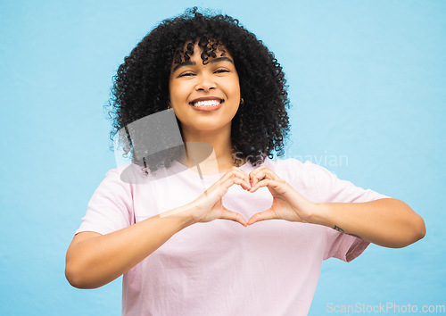 Image of Heart hand sign, black woman and smile portrait of a young person showing love gesture. African female, happiness and excited space with hands making emoji shape with blue studio background isolated